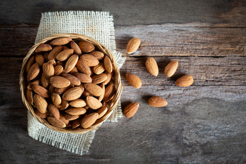 Almonds in wooden bowl on wood table,Top view.