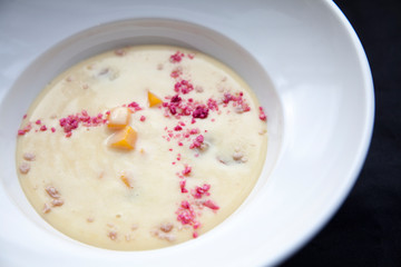 porridge with orange pumpkin slices and pink crumble close up