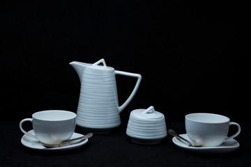 White tea set on a black background.