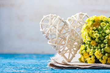 Kalanchoe flowering yellow bouquet and white heart on a wooden b