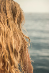 girl with wavy blonde hair near the sea