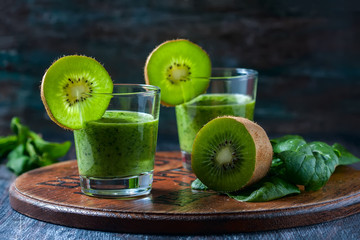 Healthy green smoothie from spinach and kiwi on a wooden table
