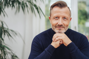 Man looking at camera with hands to his chin