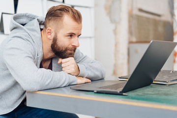 Modern man watching videos on laptop computer