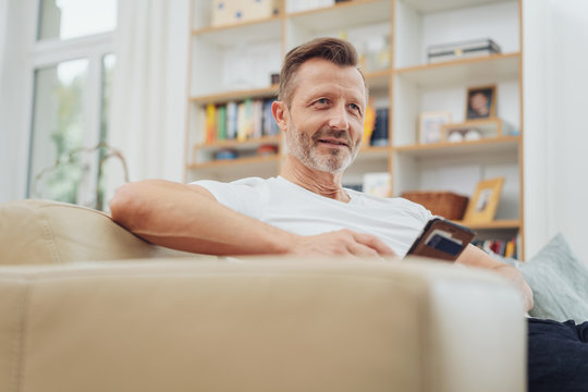 Middle-aged man sitting in a living room relaxing