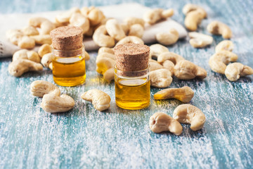 Fototapeta na wymiar cashew nuts and oil in bottle on wooden background