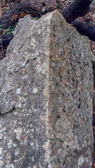 Angular granite rock formation in a forest, shown head on to the corner