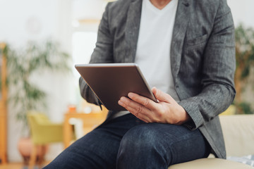 Businessman seated on the arm of a sofa