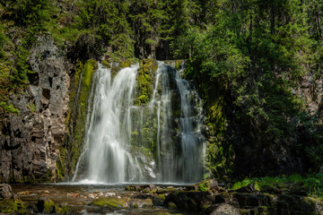 Beautiful waterfall flushing down a green rock wall