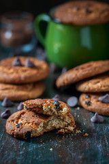 Oatmeal cookies with raisins, chocolate folded in a pile on the old table, wood background