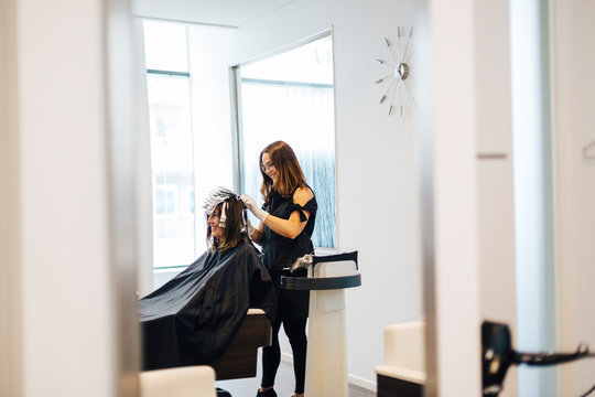 Hairdresser coloring clients hair in Sweden