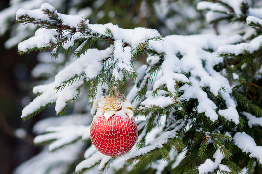 the Christmas fir-tree in snow is decorated with toys