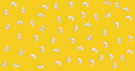 Croissant cookies sprinkled with powdered sugar on a yellow background