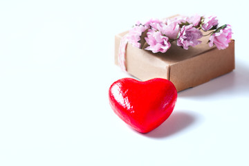 Kraft box and pink roses on white table, concept of Valentine's Day, holiday. Selective focus. Red heart.