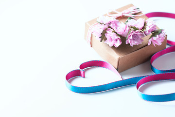 Kraft box and pink roses on white table, concept of Valentine's Day, holiday. Selective focus.