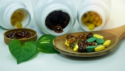 Pharmaceutical colorful pill medicine /capsules /tablets &multivitamins supplement / herbs with bottles on white background.