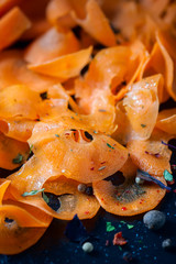 Close-up of grated carrots on dark background. Healthy diet and detox