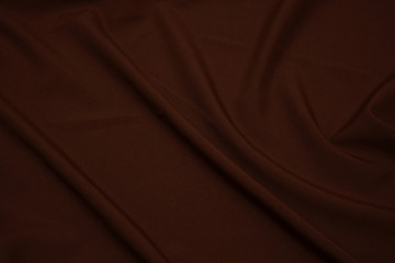 Texture of dark brown fabric closeup. Low key photo. Plexus threads. Clothing industry. Abstract background. Textile waves.