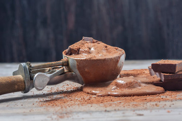 Scoop of chocolate ice cream on rustic wooden background.