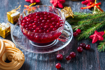 Christmas hot cranberry tea, cookies and orange slices, on dark background.