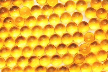 Fish oil capsules with omega 3 and vitamin D blue texture, healthy diet concept, selective focus.