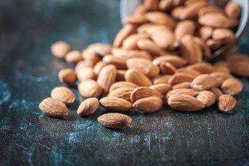 Almond on wooden background. Peeled almonds.