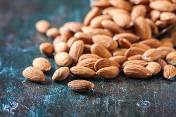 Almond on wooden background. Peeled almonds.