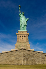Fototapeta na wymiar Front view of The Statue of Liberty on Liberty island with blue sky background, Landmarks of New York City, USA