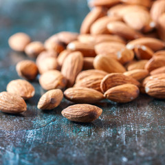 Almond on wooden background. Peeled almonds.