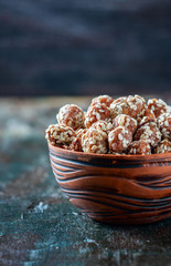Sugared peanuts with sesame seeds on the wooden background