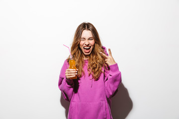 Portrait of adorable woman 20s wearing sweatshirt drinking soda using straw, isolated over white background
