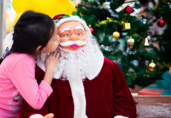 Asian child girl kiss Santa Claus puppet