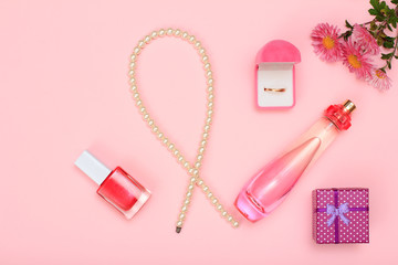 Gift boxes, perfumes and cosmetics on a pink background.