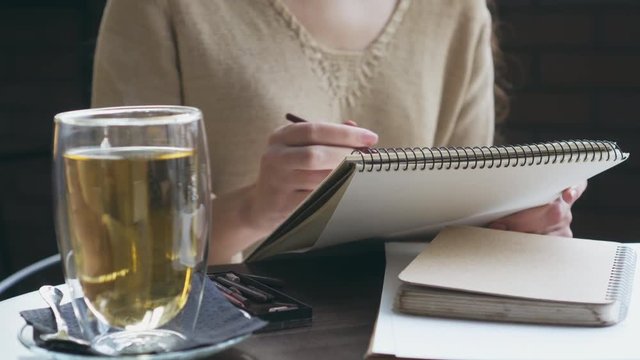 Woman drawing a sketch at cafe