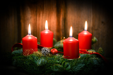 Fototapeta na wymiar Weihnachten Adventskranz mit 4 brennenden Kerzen auf altem Holz