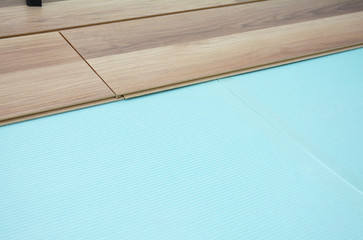 Laminate flooring installation. Close up on installing wooden laminate flooring with copy space.