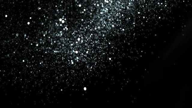 Super slow motion of glittering silver particles on black background. Shallow depth of focus. Filmed on high speed cinema camera, 1000 fps.