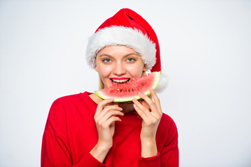 Summer treats on christmas party. Exotic christmas concept. Christmas girl eat watermelon. Exotic winter holiday. Girl wear santa hat eat slice watermelon white background. Celebrate new year summer