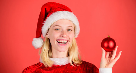 Enjoy celebration happy new year. Christmas preparation concept. Christmas fun. Girl happy wear santa costume celebrate christmas hold ball decor red background. Favorite time year christmas