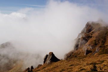Landscape from Ciucas Peak in the Carpathian Mountains, Romania,  with amazing shaped rocks, when fog is clearing on an autumn morning.
