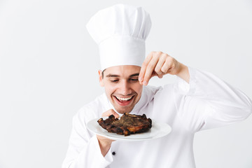 Cheerful chef cook wearing uniform peppers