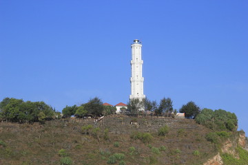 Fototapeta na wymiar lighthouse building on the beach cliff