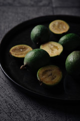Feijoa on a dark plate on a dark gray background
