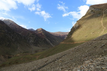 Fototapeta premium Track passing through the edge of the mountain under shiny sky