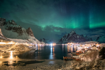 Aurora borealis over scandinavian village light shining in winter