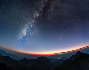 Naklejka premium Milky way galaxy with shooting star at twilight sunset