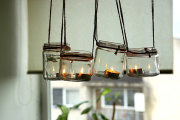 Aromatic candles in glass jars hanging in kitchen. DIY candles in glass jars hanging on linen jute. 
