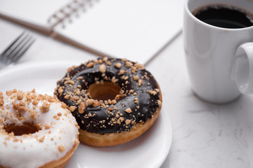 Working desk with dessert and coffee. Cake donuts with a cup of espresso on marble table top.