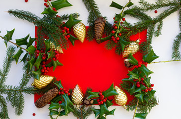 Christmas frame made of natural materials on a red background with white edges, golden Christmas...
