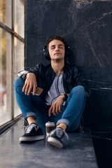 Young man listening music on headphones with his eyes closed.